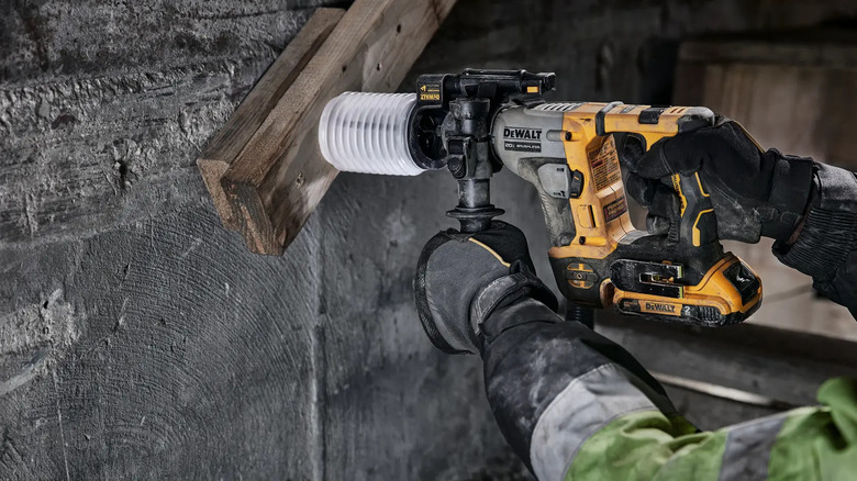 Close-up of a person using DeWalt's Atomic 20V MAX Cordless Brushless Ultra-Compact ⅝-inch SDS Plus Hammer Drill