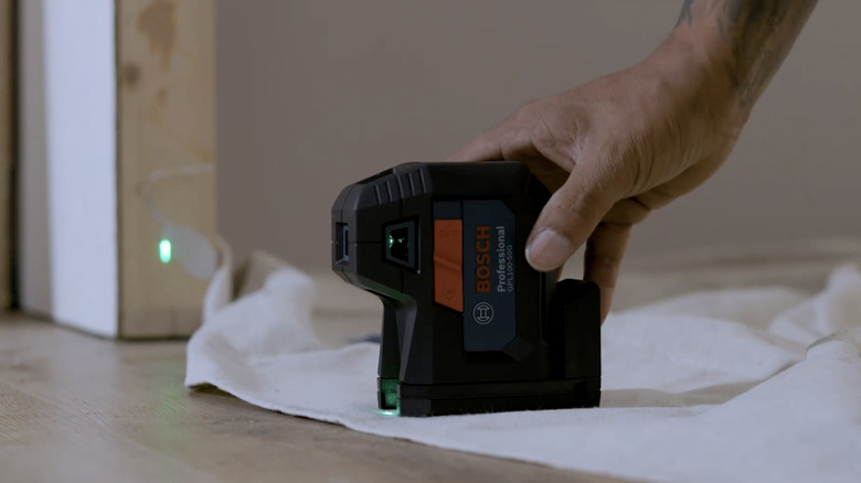 A person using the Bosch 100-foot 5-Point Laser Level