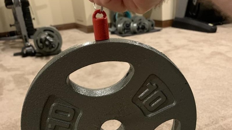 A shot showing MagnetPAL's Magnetic Stud Finder holding up a barbell weight