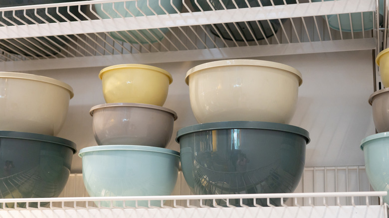 Close-up of kitchenware stacked on wire shelves