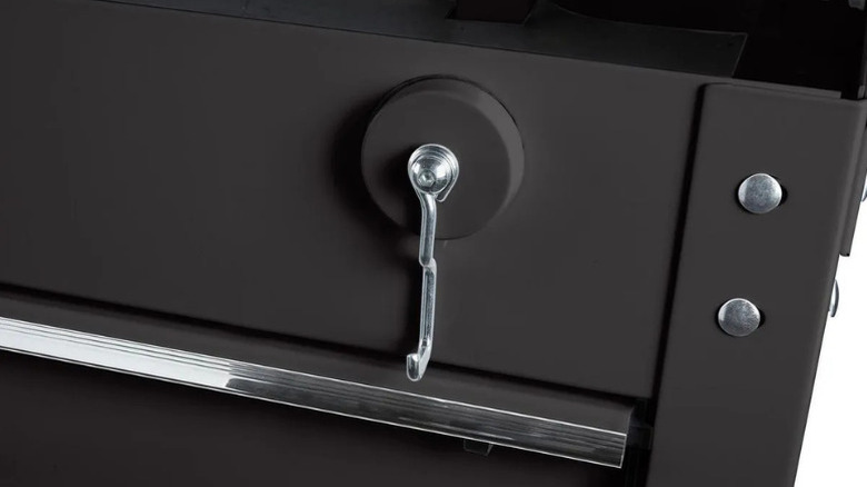 U.S. General's magnetic tool hook stuck to a black metal piece of furniture