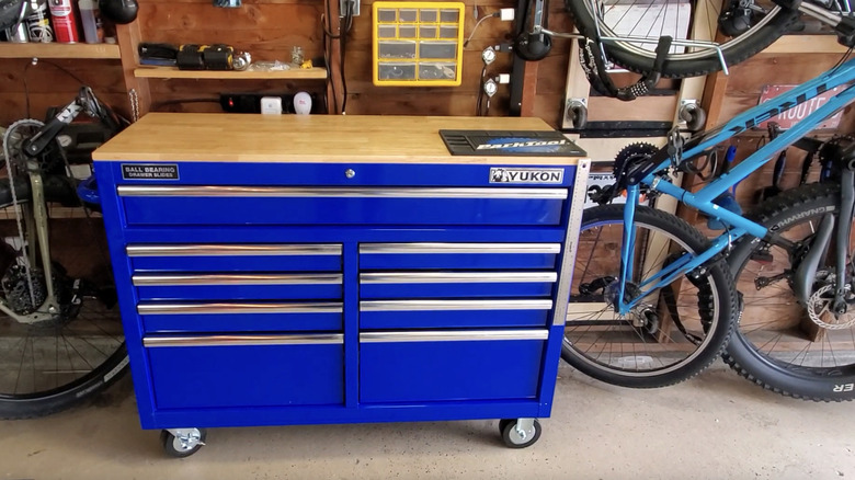 Blue mobile storage cabinet in a garage next to bicycles