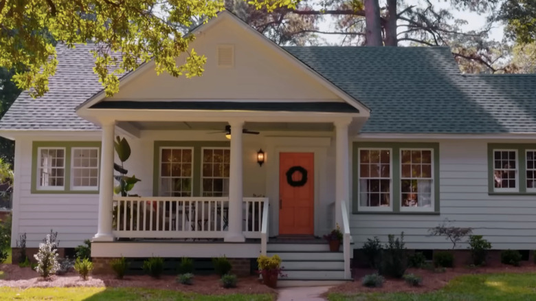 The exterior of a cottage style home with an orange door