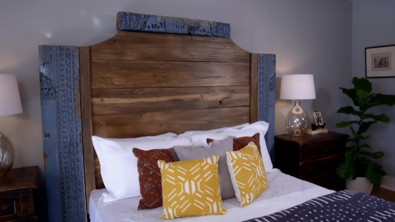 A bed with a headboard with carved wood beams.