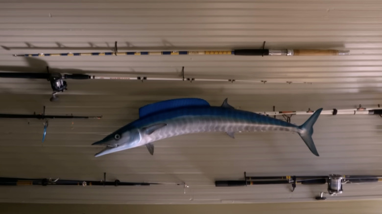 A wall with fishing poles and fish decor