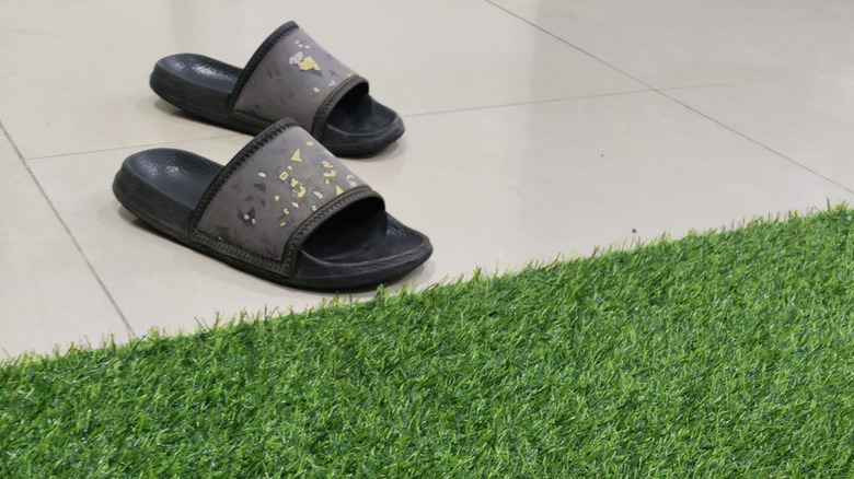 sandals next to artificial grass mat