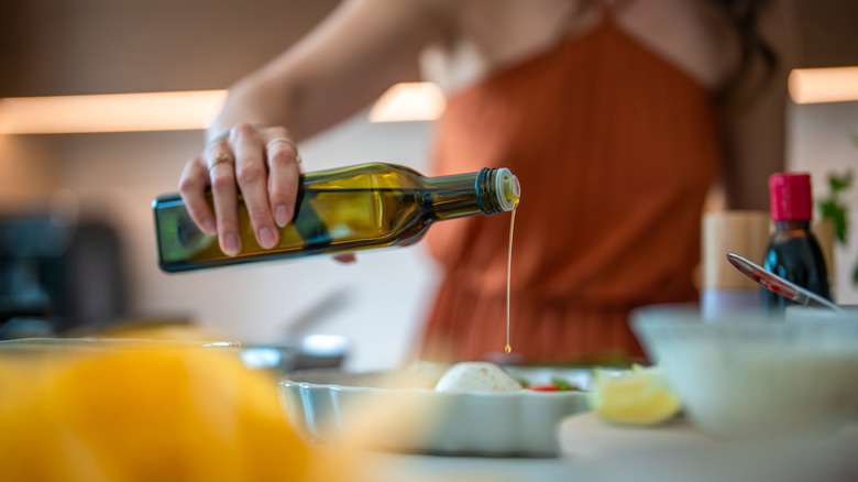 woman using cooking oil in kitchen