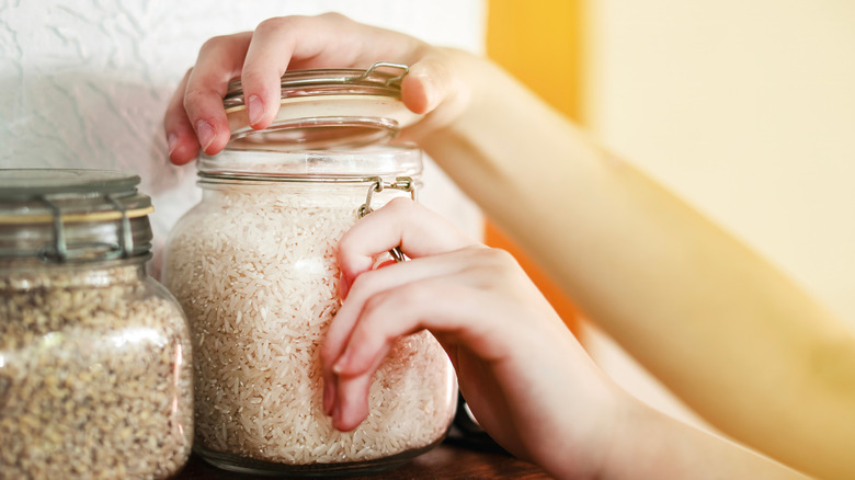 hands opening container of rice
