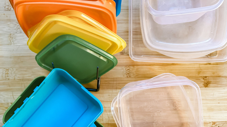 food storage containers and lids sitting unmatched on counter