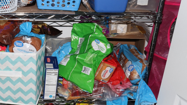 open bag of chips crammed into kitchen pantry