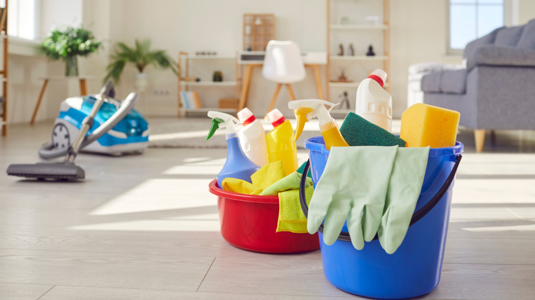 Buckets of cleaning supplies in a living room