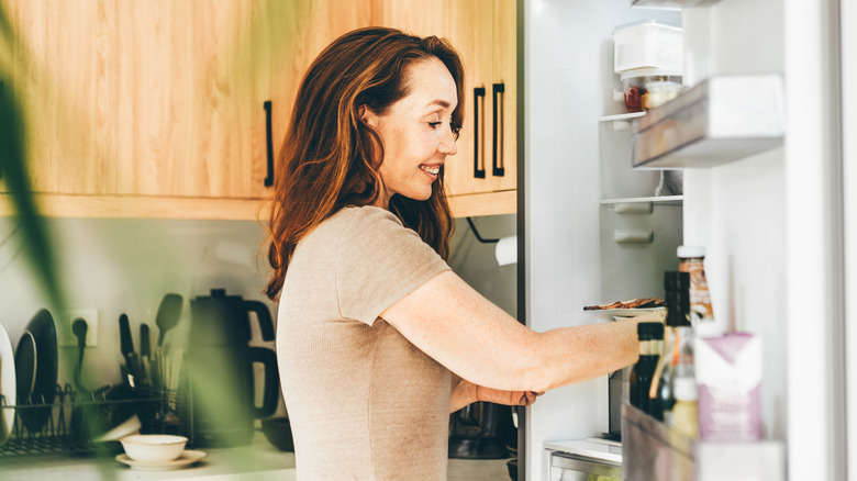A woman looking in the fridge