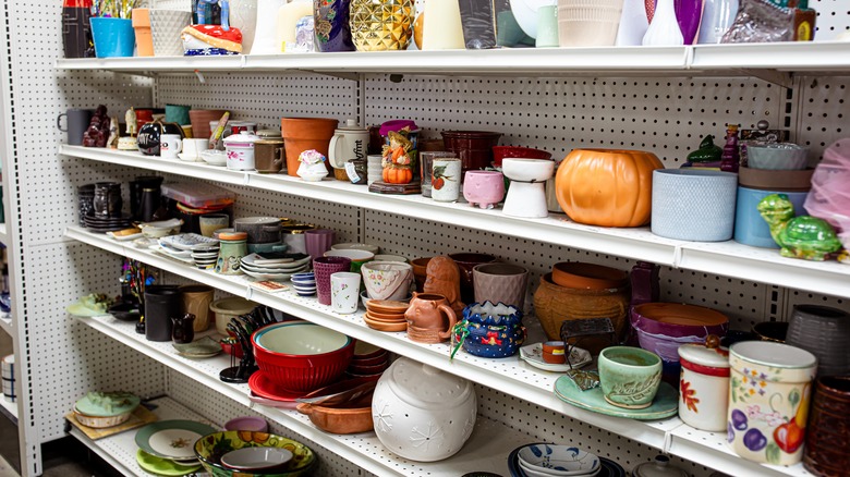 Thrift store shelves filled with jars, cups, and vases