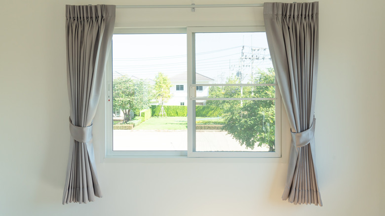 Short grey silk curtains on open window