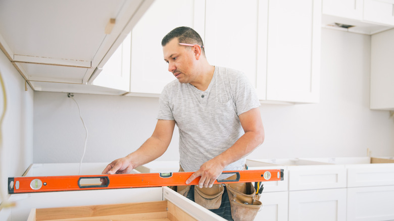 A person installing new kitchen cabinets