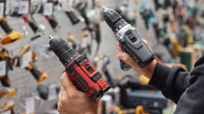 Close-up of a person viewing two cordless drills in a store