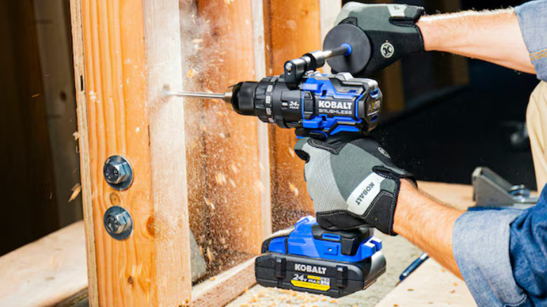 A person drilling wood with Kobalt's XTR 24V ½-inch Keyless Brushless Drill