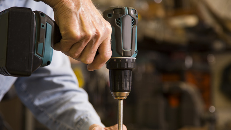 Close-up of a person using a cordless drill