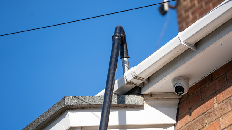 A telescopic vacuum attachment cleaning a gutter