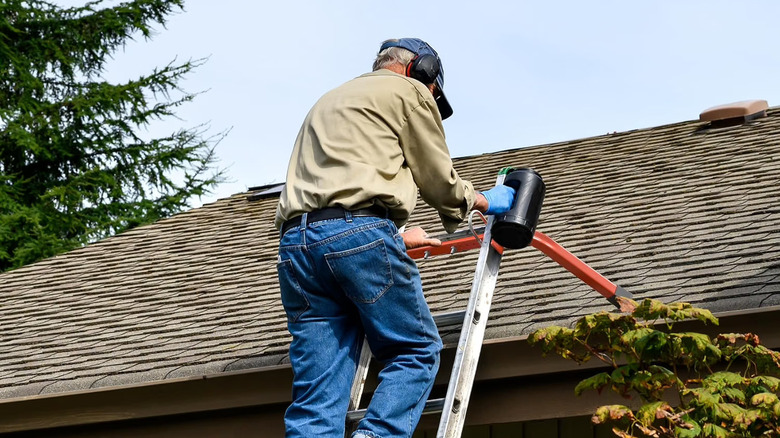 A man climbing a ladder fitted with a stabilizer