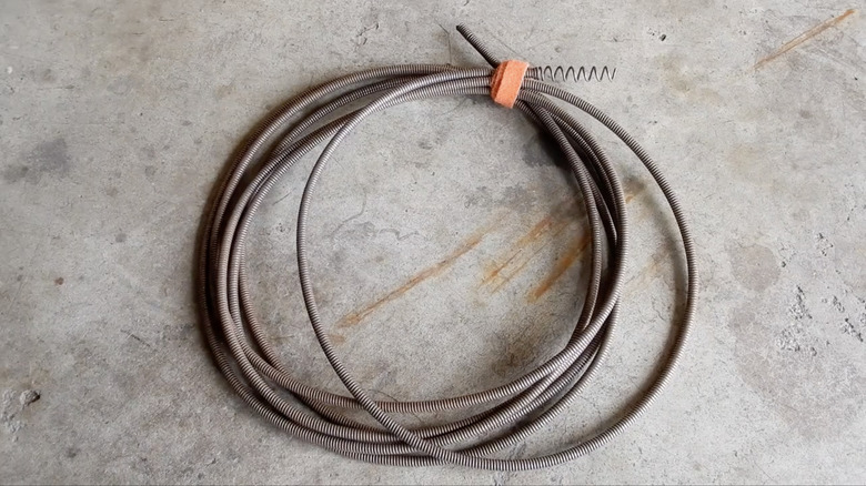 A metal auger cable used for unblocking gutter downpipes