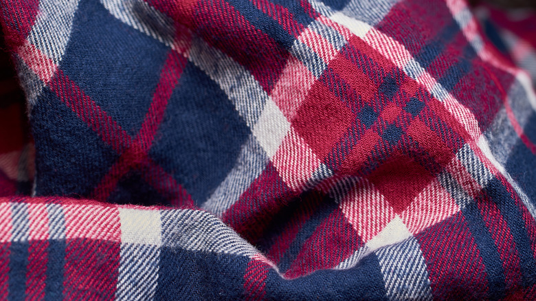 Zoomed in view of flannel fabric in a red and blue plaid pattern