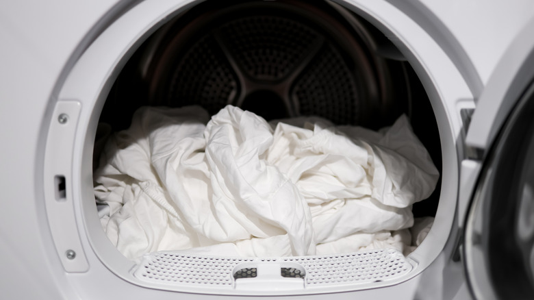 White sheets in a dryer with the door open