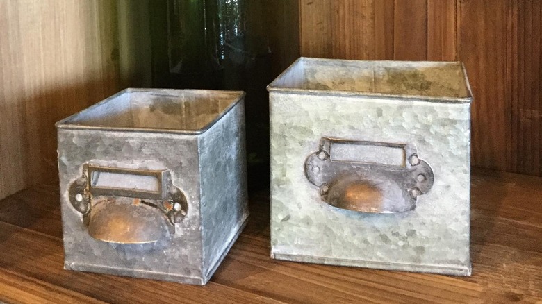 Two empty galvanized metal boxes sitting side by side
