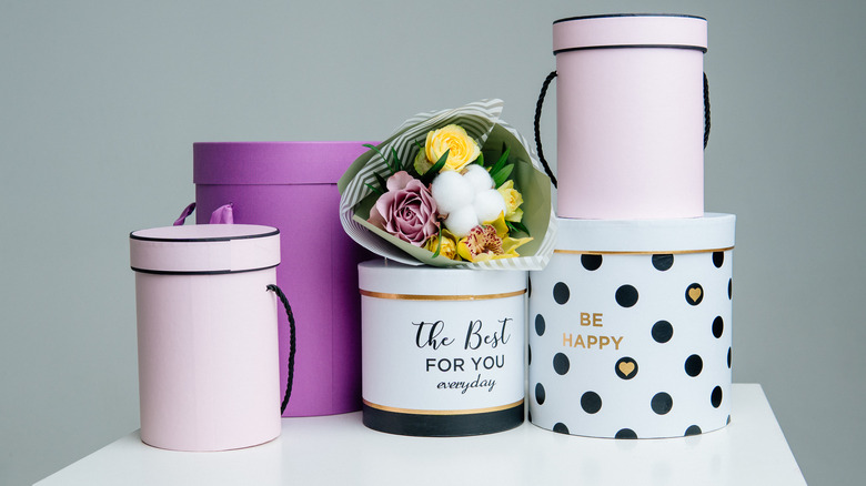 a stack of hat boxes with a flower bouquet