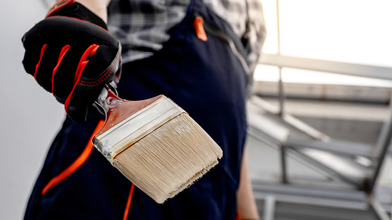 Close up of a painter holding a paintbrush
