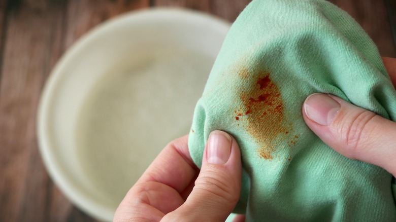 person holding stained green shirt