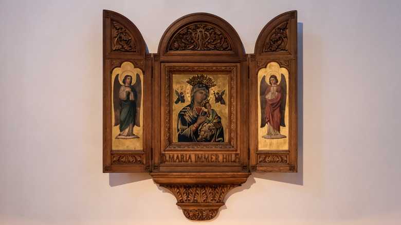 A religious triptych hanging open on a wall.