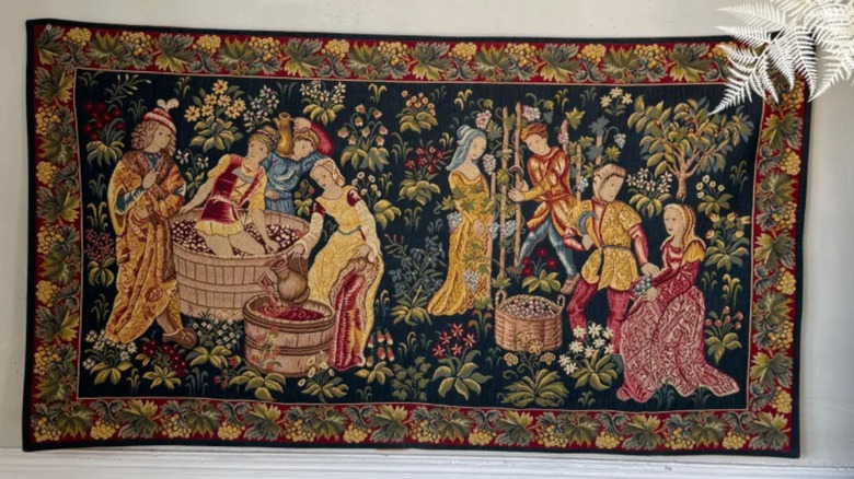 A grape harvest tapestry on wall.