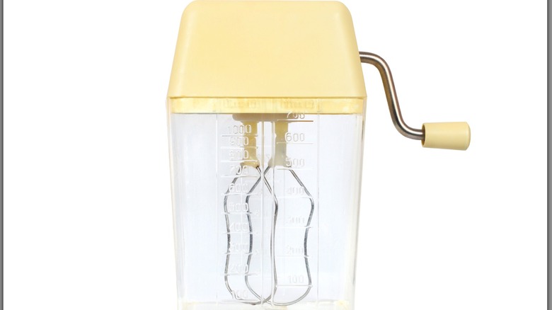 A vintage hand mixer on a white background.