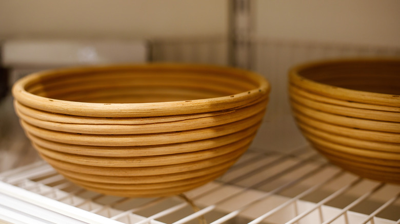 A close up of a proofing basket sitting on a wired shelf.