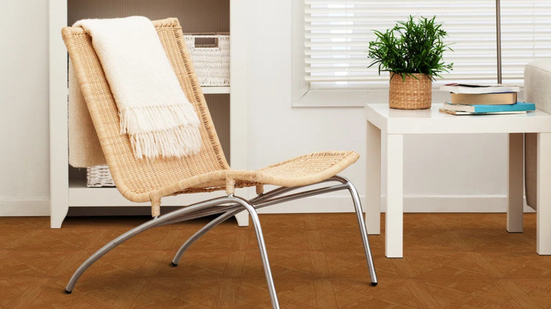 A desk chair on golden stained faux wood floors.