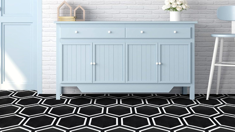 A blue cabinet on a black and white hexagonal floor.