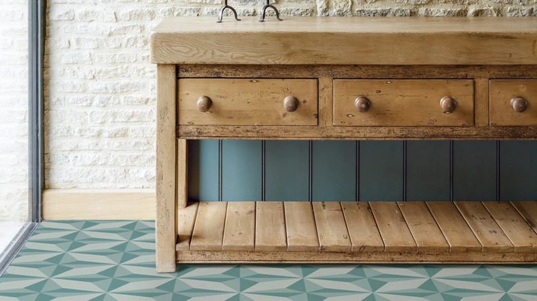 A light wood table on pale blue geometric tiling.