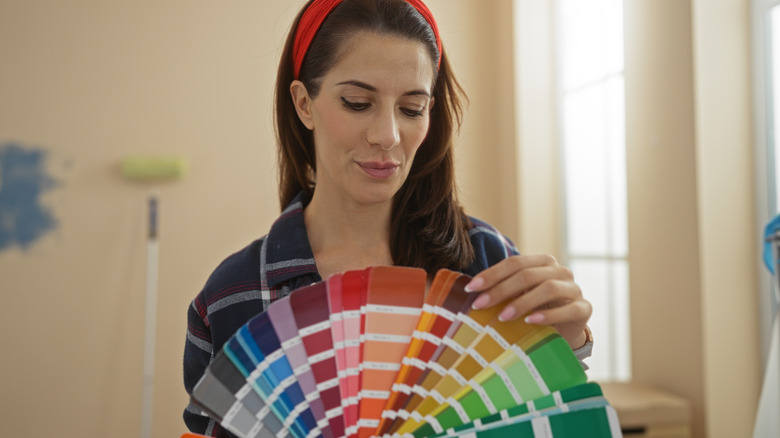 Woman choosing paint colors from swatches.