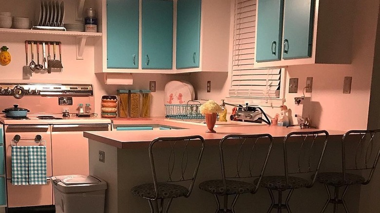 Pale pink kitchen with aqua cabinets.
