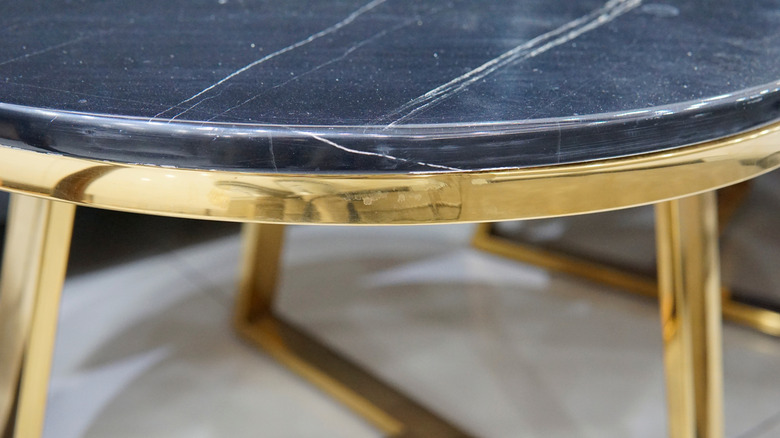 coffee table with black quartz surface and gold legs