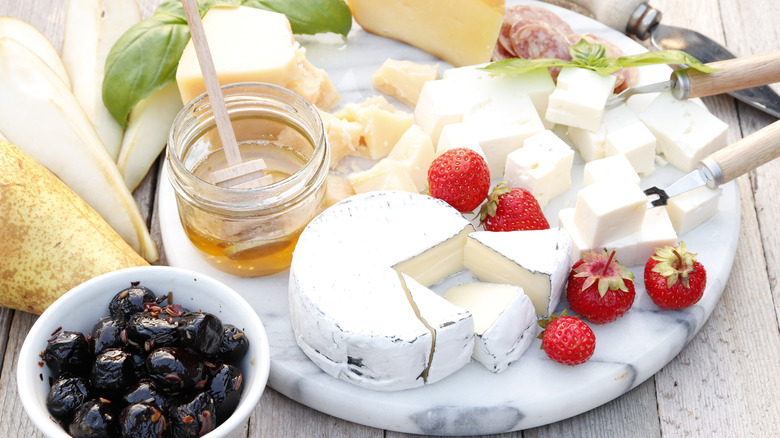 round marble cheeseboard with fruit and cheese