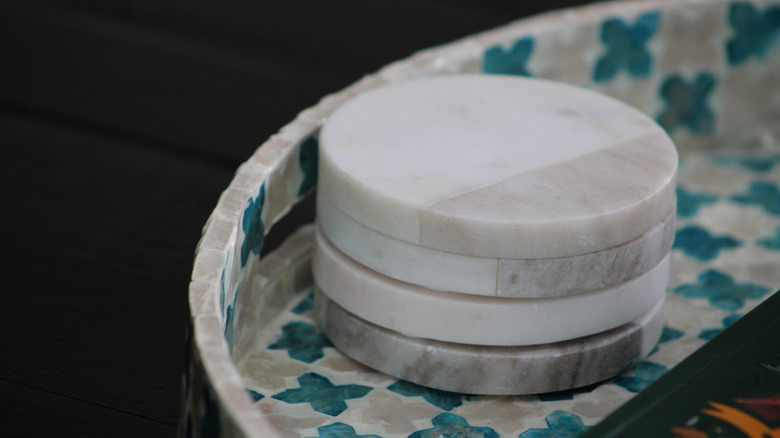 stack of white marble coasters in a tray