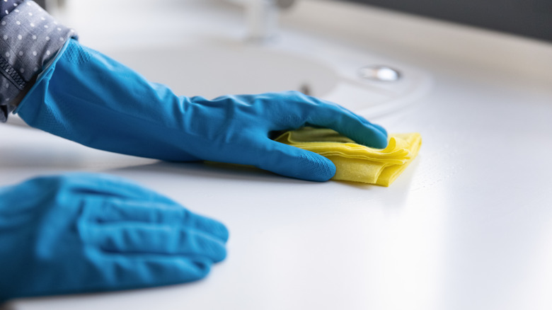 Person wiping bathroom counter