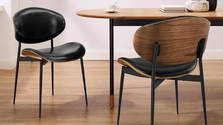 Black leather MCM dining seats next to a table