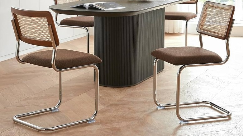 Chrome cantilevelered dining chairs with uholstered seats and rattan backrests