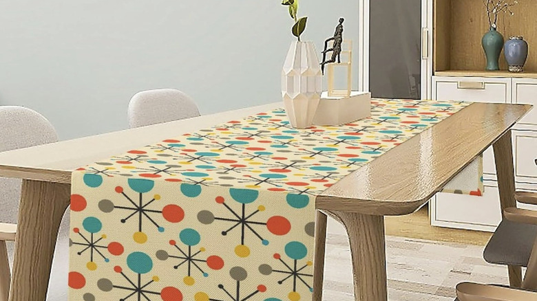 A table runner from Focusbrite on a mid-century modern dining table in a light finish