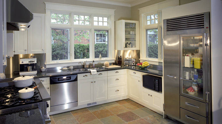 A u-shaped kitchen with traditional windows.