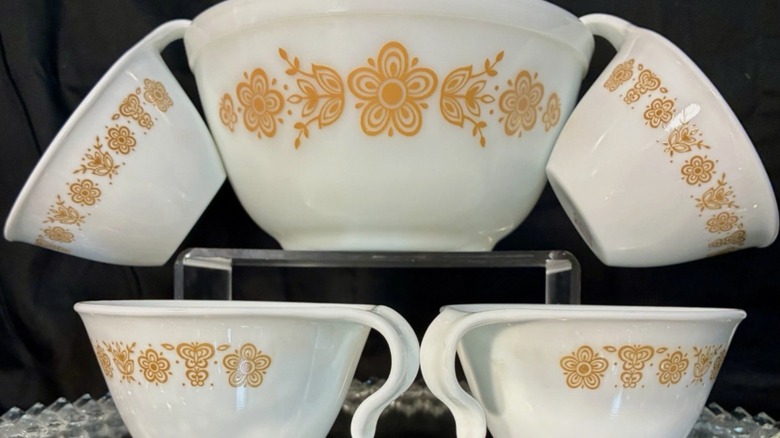 A set of white Pyrex Butterfly Gold teacups and matching bowl