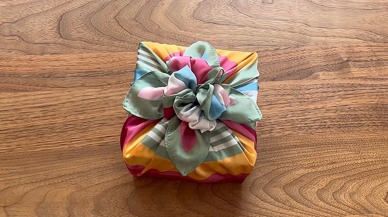 Square present wrapped in a colorful scarf